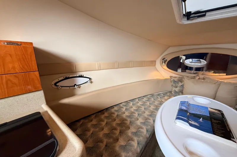 Slide: The Image of 2007 Glastron GS 279 cabin interior with cozy seating and elegant wood accents. - 20