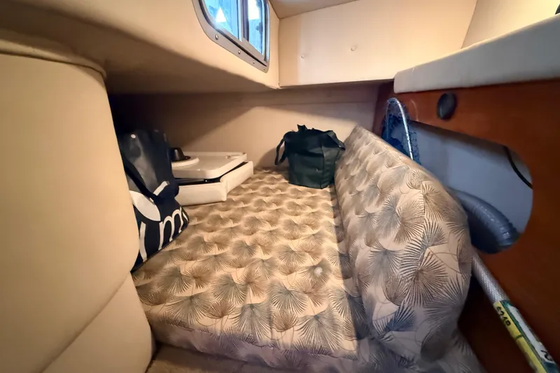 Slide: The Image of 2007 Glastron GS 279 cabin interior with patterned bedding and storage bags. - 26