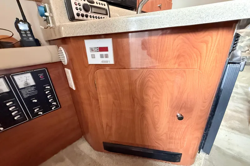 Slide: The Image of 2007 Glastron GS 279 boat interior with control panels and wood cabinetry. - 27