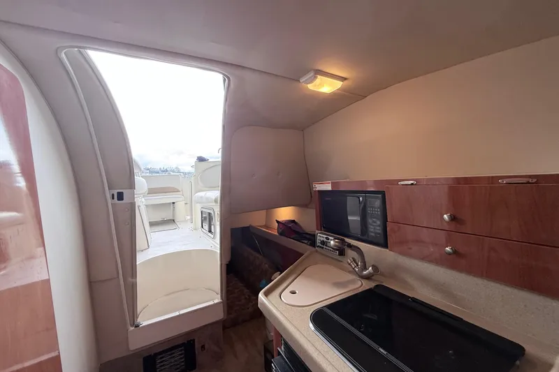 Slide: The Image of 2007 Glastron GS 279 boat interior with kitchenette and open cabin door. - 30
