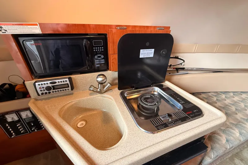 Slide: The Image of 2007 Glastron GS 279 boat kitchenette with sink, stove, and microwave. - 34