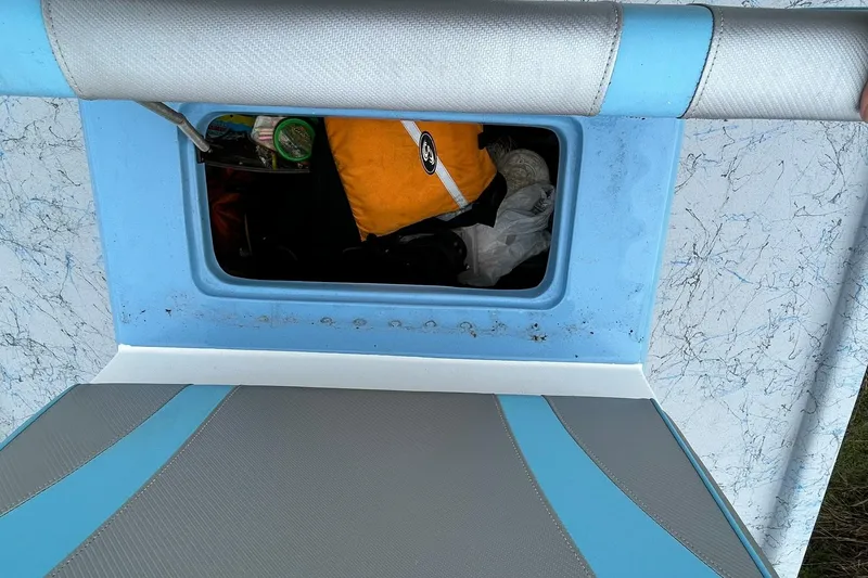 Slide: The Image of Interior storage compartment of 2022 Transcat 200 SVT boat, featuring blue and gray upholstery. - 24