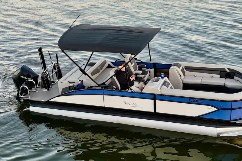Slide: The Image of 2024 Barletta Cabrio 24UC pontoon boat cruising on calm water. - 12