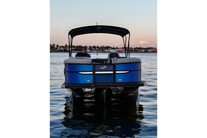 Slide: The Image of 2024 Barletta Cabrio 24UC pontoon boat on calm water at sunset. - 14