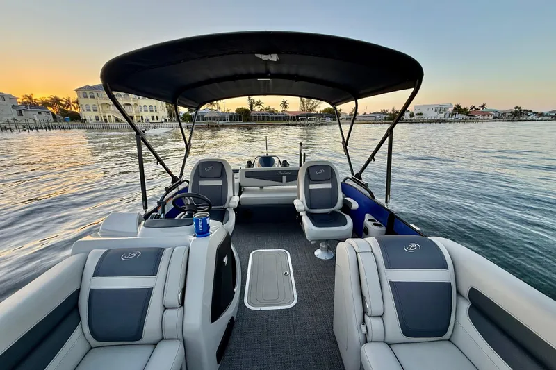Slide: The Image of 2024 Barletta Cabrio 24UC pontoon boat interior at sunset on calm water. - 16