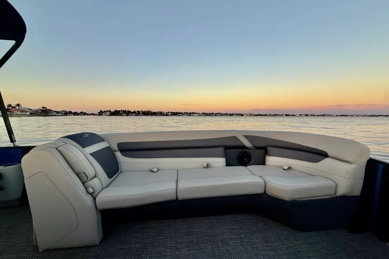 Slide: The Image of 2024 Barletta Cabrio 24UC pontoon boat interior at sunset on calm water. - 17