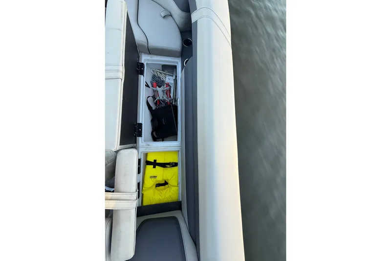 Slide: The Image of 2024 Barletta Cabrio 24UC boat storage compartment with safety gear and equipment. - 23