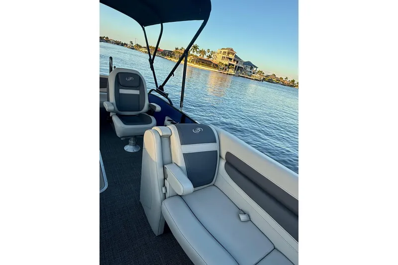 Slide: The Image of 2024 Barletta Cabrio 24UC pontoon boat interior with lake view and luxurious seating. - 26