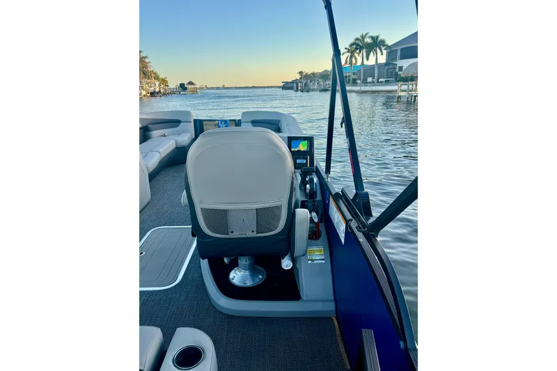 Slide: The Image of 2024 Barletta Cabrio 24UC boat interior with captain's chair and water view. - 30