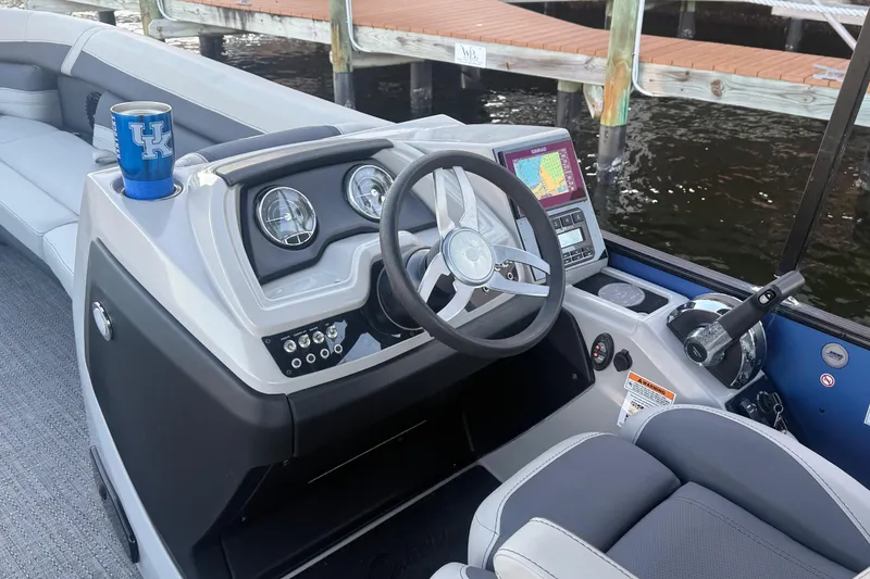 Slide: The Image of 2024 Barletta Cabrio 24UC boat dashboard with steering wheel and navigation system. - 33