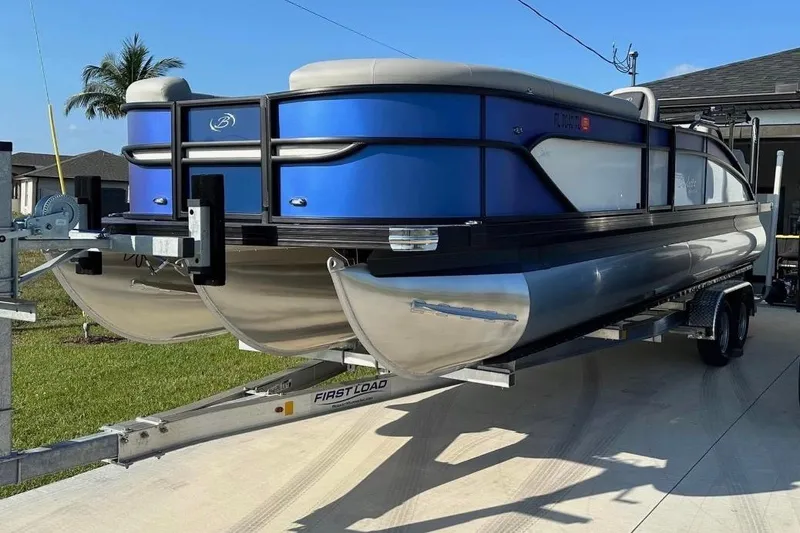 Slide: The Image of 2024 Barletta Cabrio 24UC pontoon boat on trailer, parked outdoors. - 35