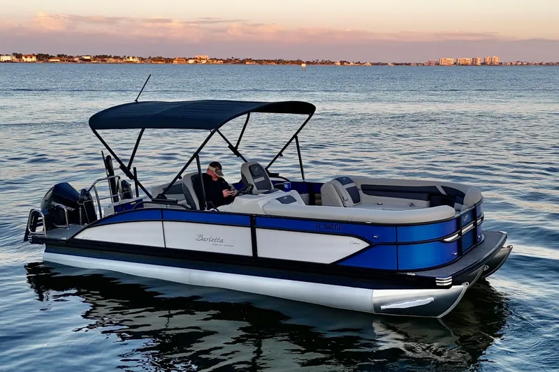 Slide: The Image of 2024 Barletta Cabrio 24UC pontoon boat on calm water at sunset. - 5