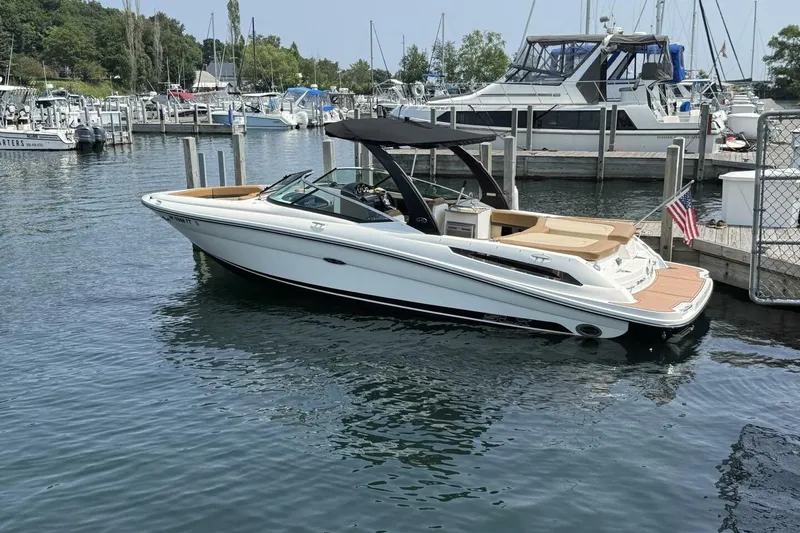Slide: The Image of 2016 Sea Ray SLX 250 boat docked in a marina, featuring sleek design and American flag. - 1