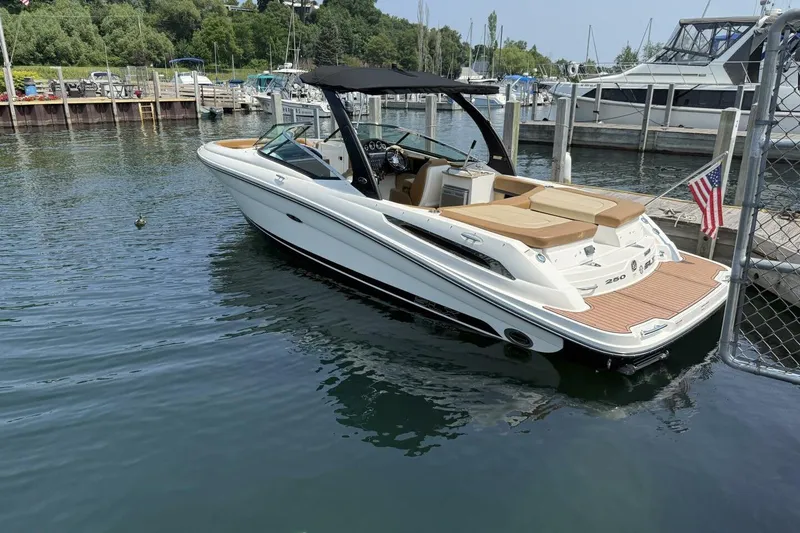 Slide: The Image of 2016 Sea Ray SLX 250 boat docked in a marina, featuring sleek design and tan seating. - 2