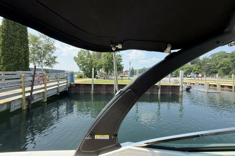 Slide: The Image of 2016 Sea Ray SLX 250 boat docked at a serene waterfront with lush greenery. - 25