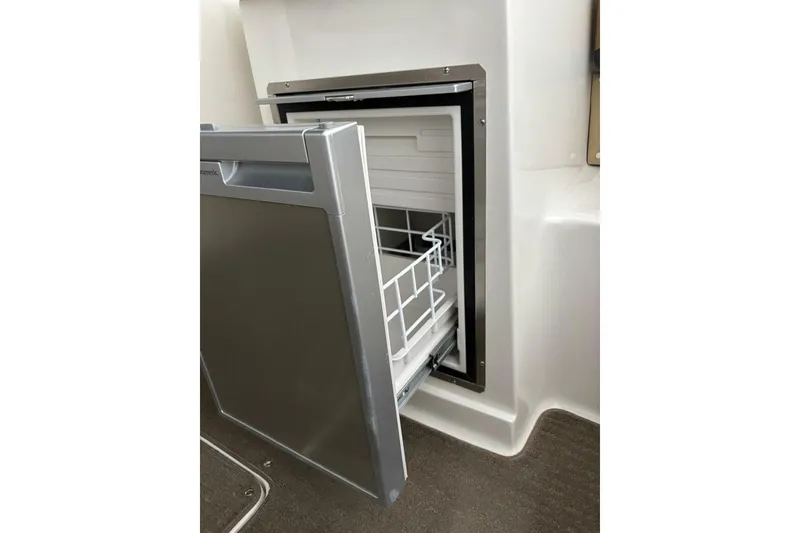 Slide: The Image of Open refrigerator on 2016 Sea Ray SLX 250 boat, showcasing interior storage space. - 27