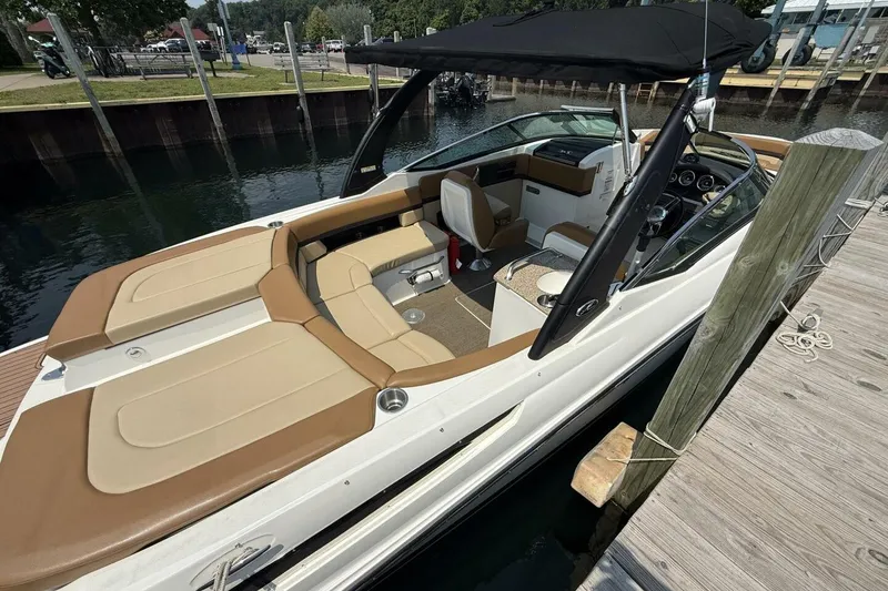 Slide: The Image of 2016 Sea Ray SLX 250 boat docked, featuring tan seating and black canopy. - 4