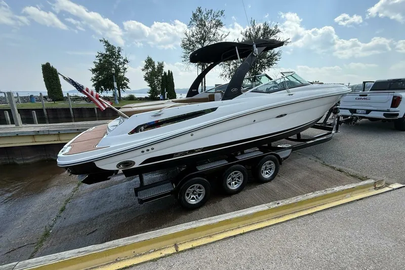 Slide: The Image of 2016 Sea Ray SLX 250 boat on trailer, dockside with American flag. - 41