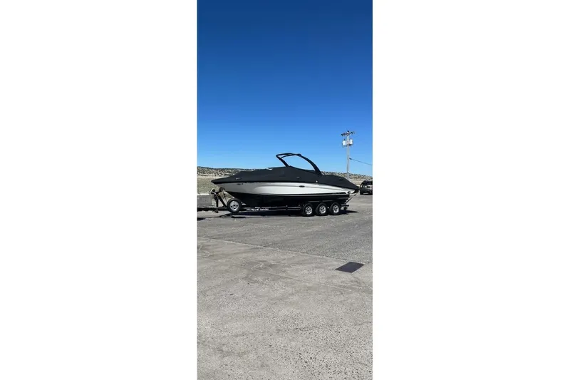 Slide: The Image of 2016 Sea Ray SLX 250 boat on trailer under clear blue sky. - 46