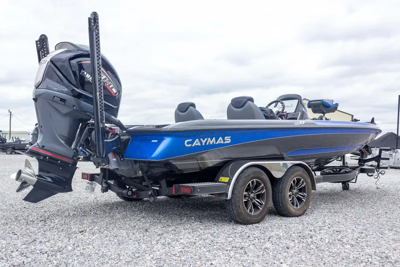 Slide: The Image of 2023 Caymas CX 21 PRO boat with Yamaha engine on a trailer, parked on gravel. - 13
