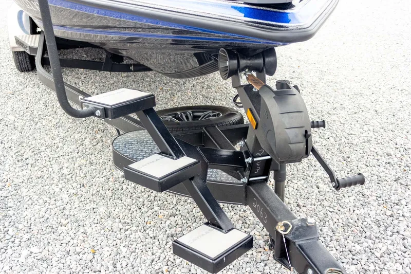 Slide: The Image of 2023 Caymas CX 21 PRO boat trailer with steps on gravel surface. - 18