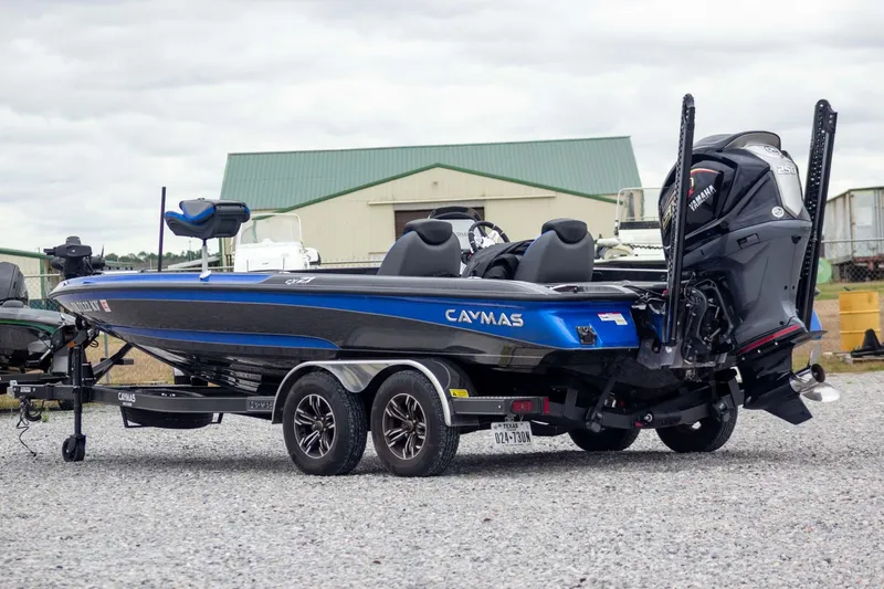 Slide: The Image of 2023 Caymas CX 21 PRO boat on trailer, blue and black design, parked outdoors. - 8