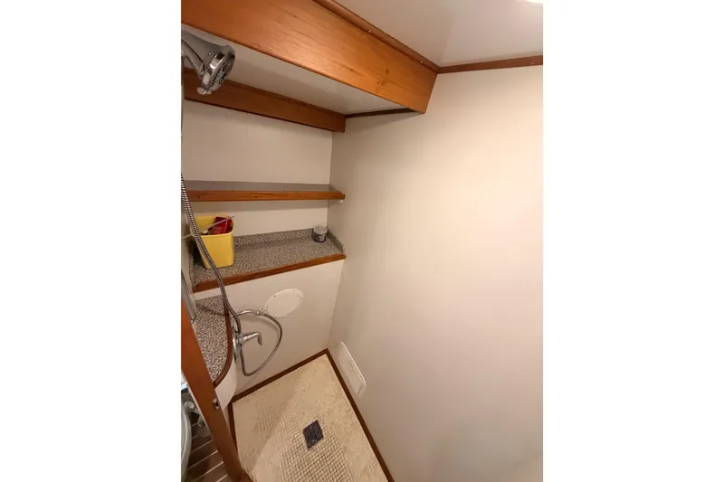 Slide: The Image of 1984 Hartman-Palmer yacht bathroom with shower, wooden shelves, and tiled floor. - 105