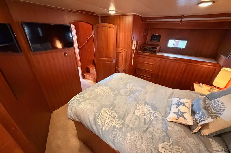 Slide: The Image of Luxurious 1984 Hartman-Palmer yacht bedroom with wood paneling and nautical-themed bedding. - 106