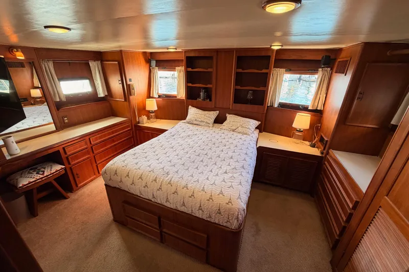 Slide: The Image of Luxurious 1984 Hartman-Palmer 60 Flush Deck Motor Yacht bedroom with wood paneling and cozy decor. - 108