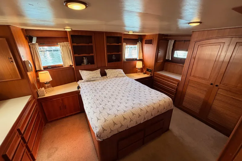 Slide: The Image of Luxurious 1984 Hartman-Palmer 60 Flush Deck Motor Yacht bedroom with wood paneling and cozy decor. - 114