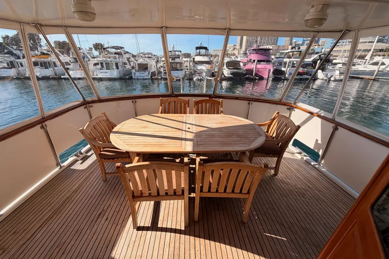 Slide: The Image of 1984 Hartman-Palmer 60 Flush Deck Motor Yacht with wooden deck and dining area. - 123