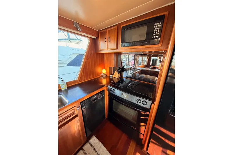 Slide: The Image of 1984 Hartman-Palmer yacht kitchen with wood cabinetry, modern appliances, and window view. - 21