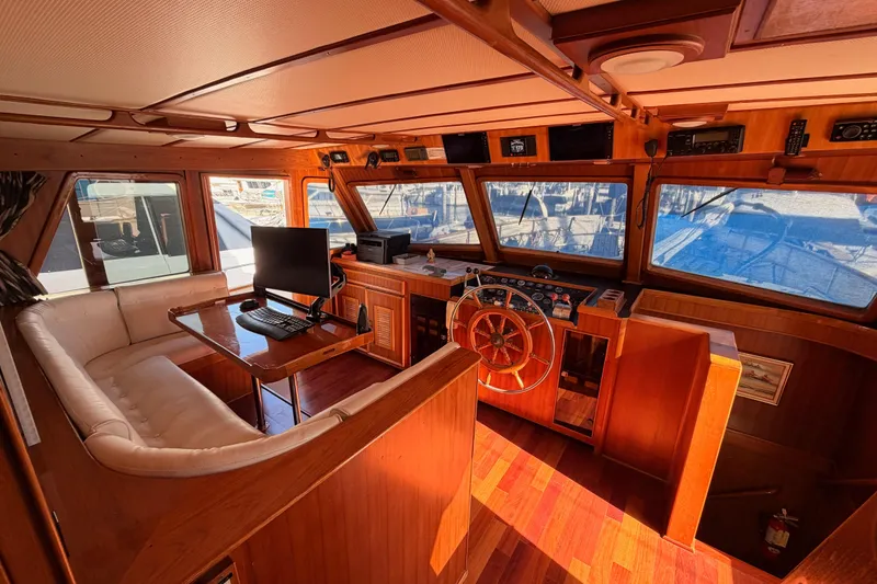 Slide: The Image of 1984 Hartman-Palmer 60 Flush Deck Motor Yacht interior with wooden helm and seating area. - 28