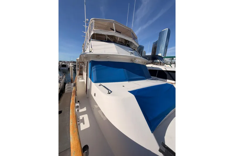 Slide: The Image of 1984 Hartman-Palmer 60 Flush Deck Motor Yacht docked, featuring blue covers and city skyline backdrop. - 36