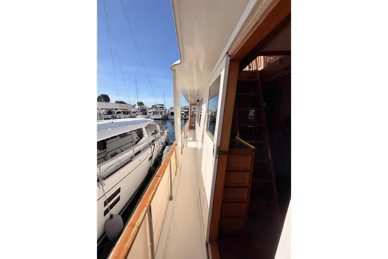 Slide: The Image of 1984 Hartman-Palmer 60 Flush Deck Motor Yacht docked, showcasing side deck and cabin entrance. - 38