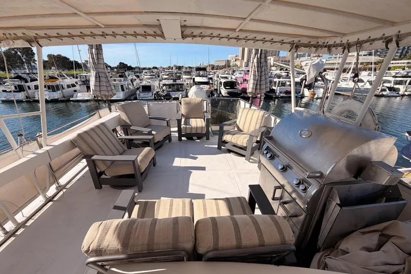 Slide: The Image of 1984 Hartman-Palmer 60 Flush Deck Motor Yacht with outdoor seating and grill at marina. - 56