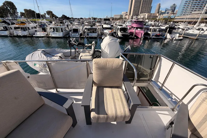 Slide: The Image of 1984 Hartman-Palmer 60 Flush Deck Motor Yacht at marina, with city skyline backdrop. - 57