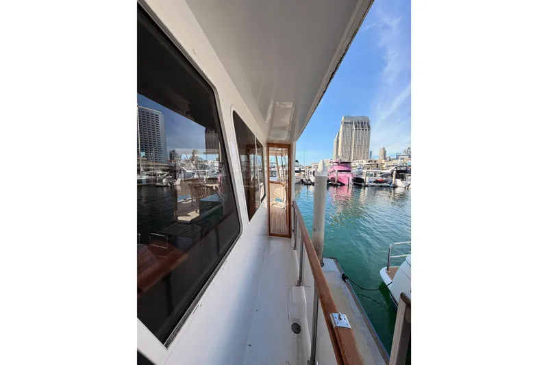 Slide: The Image of 1984 Hartman-Palmer 60 Flush Deck Motor Yacht docked in marina, cityscape background. - 7