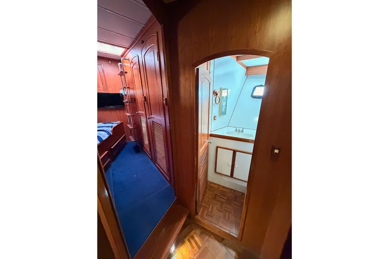 Slide: The Image of Interior of 1984 Hartman-Palmer 60 Flush Deck Motor Yacht, featuring wood paneling and compact bathroom. - 79
