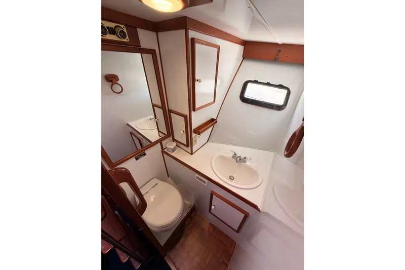 Slide: The Image of 1984 Hartman-Palmer 60 Flush Deck Motor Yacht bathroom with sink, toilet, and mirror. - 84