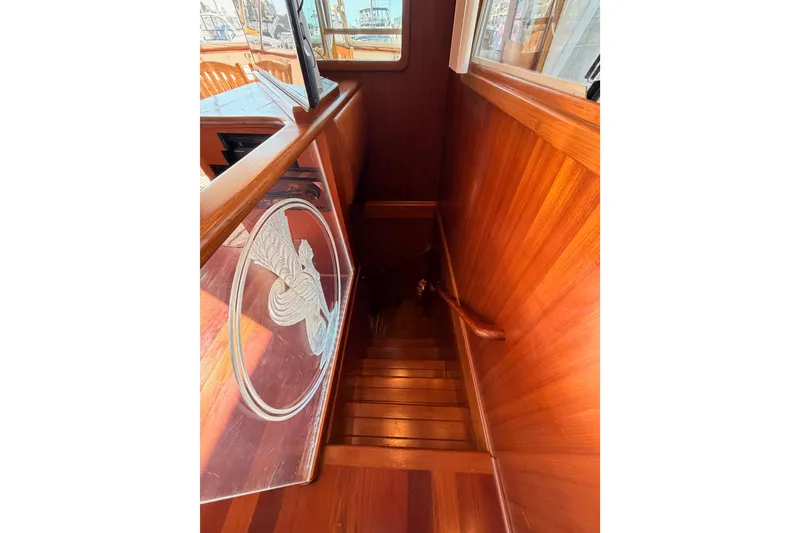 Slide: The Image of Wooden staircase on 1984 Hartman-Palmer 60 Flush Deck Motor Yacht, featuring etched glass panel. - 94