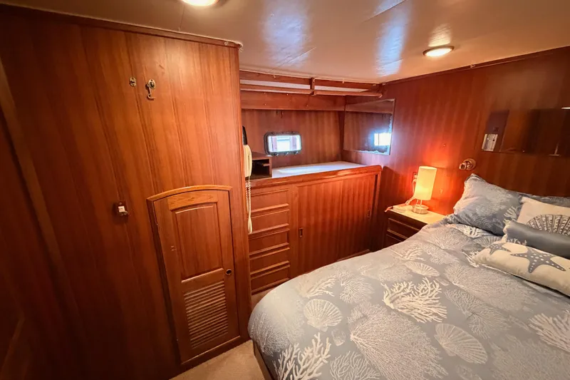 Slide: The Image of Cozy bedroom interior of 1984 Hartman-Palmer 60 Flush Deck Motor Yacht with wood paneling. - 99