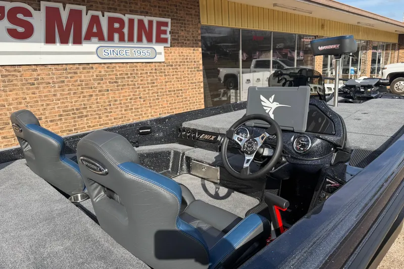 Slide: The Image of 2026 Phoenix 921 Elite X boat interior with steering wheel and seats at a marine dealership. - 3