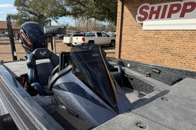 Slide: The Image of 2026 Phoenix 921 Elite X boat with sleek design, parked near a brick building. - 9