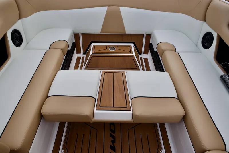 Slide: The Image of 2024 Moomba Max interior with tan and white seating, featuring wood accents and built-in speakers. - 10