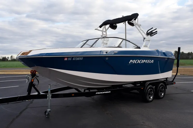 Slide: The Image of 2024 Moomba Max boat on trailer, blue and white design, parked outdoors. - 17