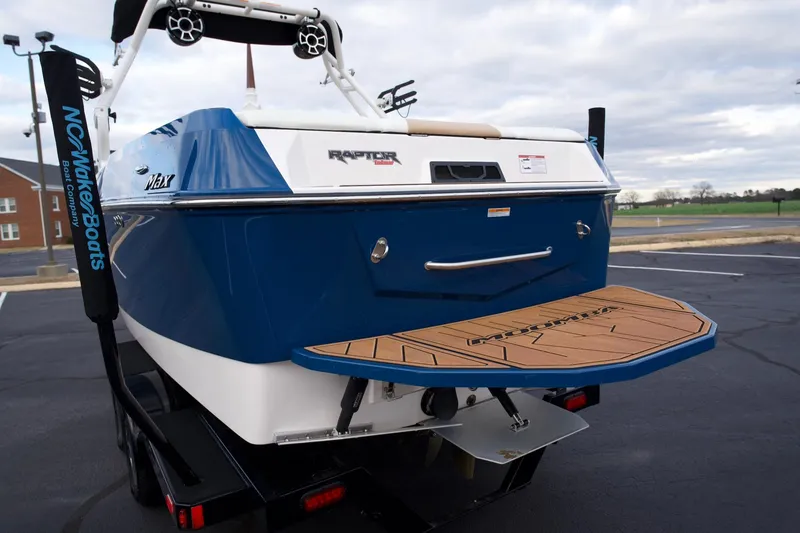 Slide: The Image of 2024 Moomba Max boat rear view with swim platform and Raptor engine branding. - 18