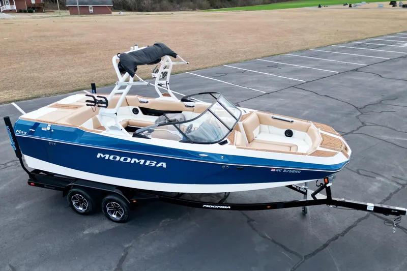 Slide: The Image of 2024 Moomba Max boat on trailer, blue and white design, parked in open lot. - 20
