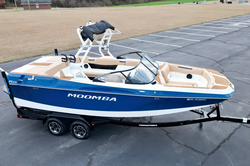 Slide: The Image of 2024 Moomba Max boat on trailer, blue and white design, parked in an empty lot. - 24