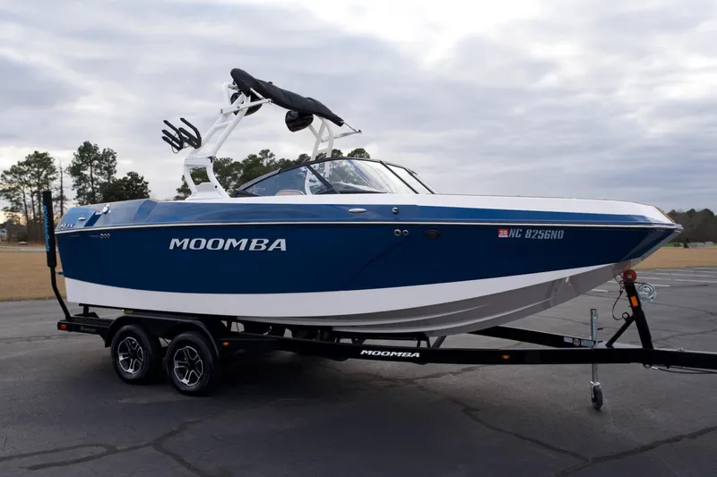 Slide: The Image of 2024 Moomba Max boat on trailer, blue and white design, parked outdoors. - 3